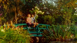 Los protagonistas de Una segunda vida sentados en un puente de un jardín
